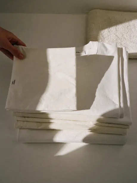rosaodor-editorial-folded-white-laundry-with-hand